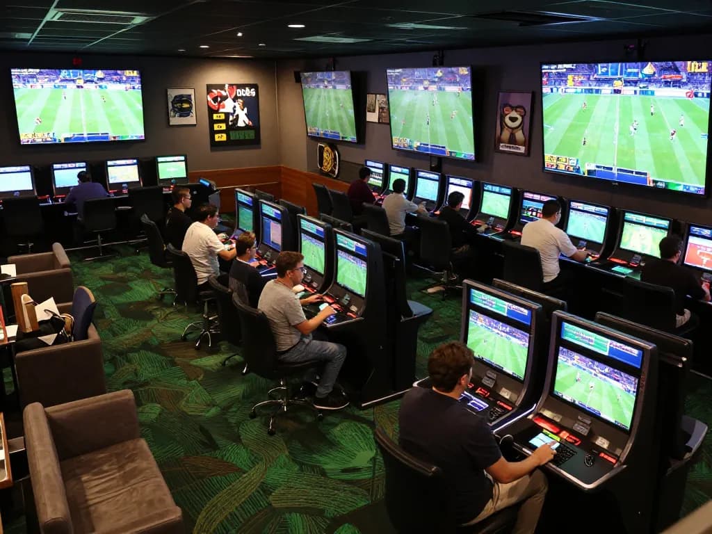 Experience thrilling sports betting action at bk8 with multiple screens and enthusiastic bettors.